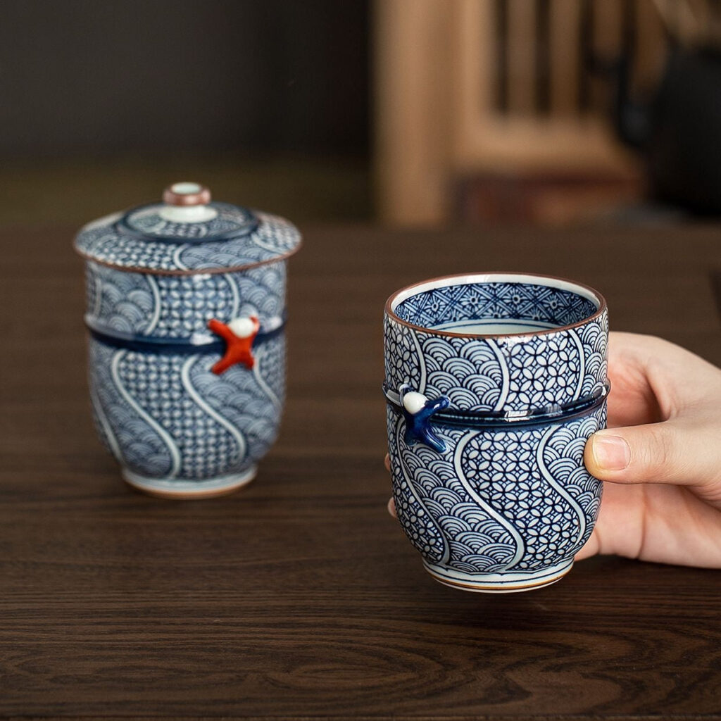 Arita Ware lidded ceramic teacup displayed alongside elegant Japanese tableware